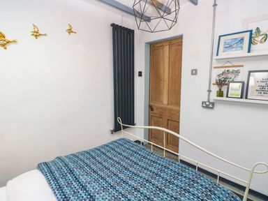 A bedroom with a bed and a door at Cattle Shed near Narberth
