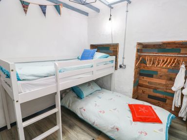 A bedroom with a bunk bed and wooden storage at Cattle Shed near Narberth