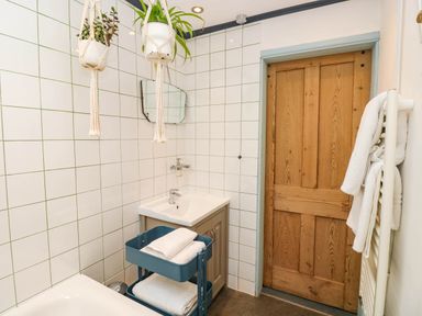 A bathroom with sink, bath tub, and storage cart at Cattle Shed near Narberth