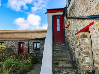 A staircase leading to a red door at Hayloft near Narberth