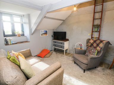 A living room with a sofa and armchair at Hayloft near Narberth
