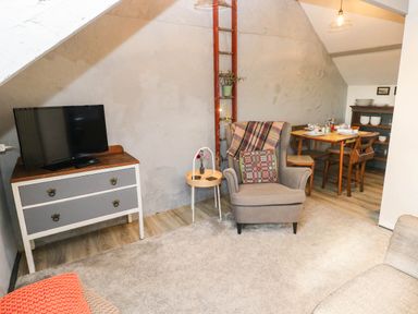 A living room with a television and seating at Hayloft near Narberth