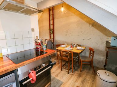 A kitchen with a stove and dining table at Hayloft near Narberth