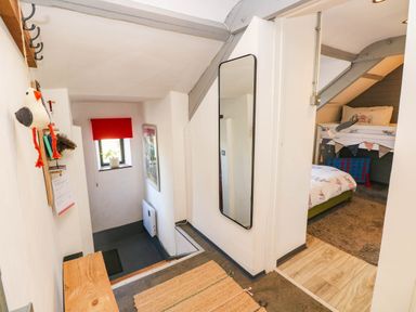 A hallway with stairs and a mirror at Hayloft near Narberth