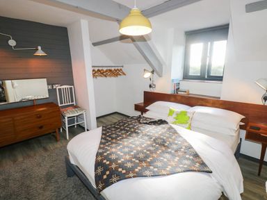 A bedroom with a bed, lamp, and mirror at Hayloft near Narberth