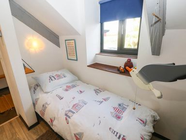 A bedroom with a bed and decorative items at Hayloft near Narberth