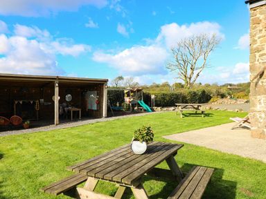 A garden with seating and a playhouse at Hayloft near Narberth