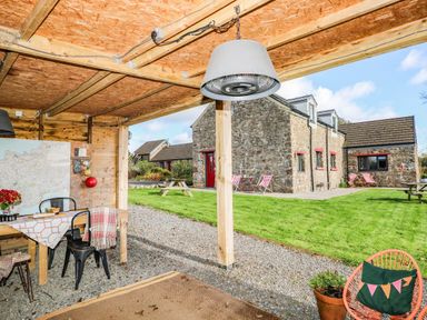 An outdoor dining area with a table and chairs at Milking Shed near Narberth
