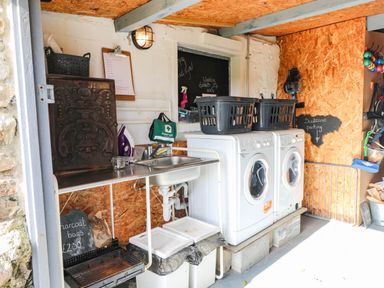 A laundry room with washing machines and a sink at Milking Shed near Narberth