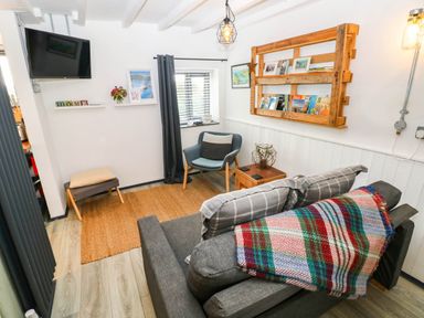 A living room with a sofa and armchair at Milking Shed near Narberth