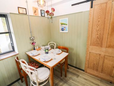 A dining room with a table set for meals at Milking Shed near Narberth