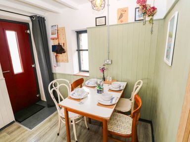 A dining area with a table and chairs at Milking Shed near Narberth