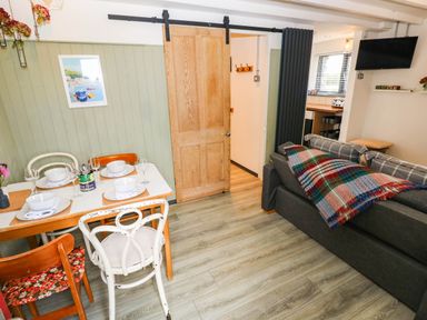 A living room with a dining area and sofa at Milking Shed near Narberth