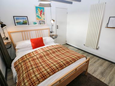 A bedroom with a bed and a blanket at Milking Shed near Narberth