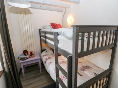 A bedroom with bunk beds and a table at Milking Shed near Narberth
