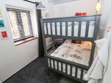 A bedroom with a bunk bed and window at Milking Shed near Narberth