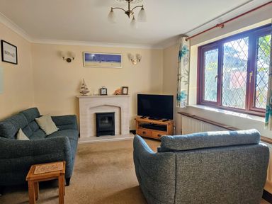 A living room with a fireplace and television at Chiffchaff in Padstow