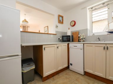 A kitchen with a refrigerator a microwave a dishwasher a sink and cabinets at Dartmoor 2 in Callington