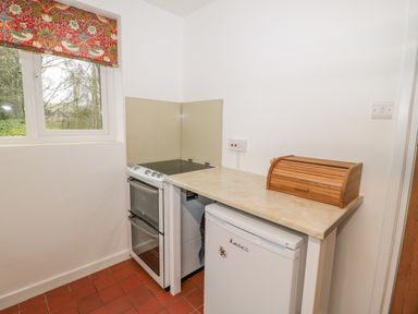 A kitchen corner with a stove oven fridge bread box and window at West Burnbank in Tarset near Bellingham