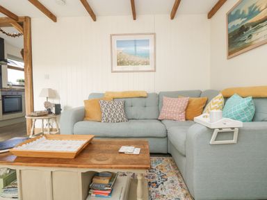 A living room with a light blue corner sofa and wooden coffee table at The Lily Pad in Camborne