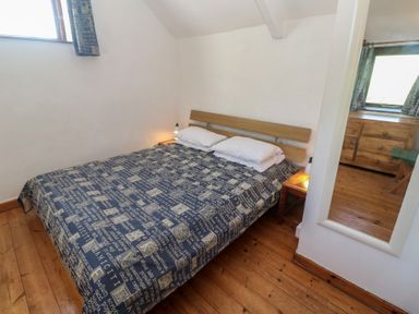 A bedroom with a bed and nightstand at Kernyk in Penzance