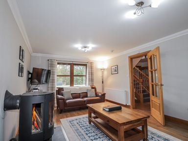 A living room with a sofa and coffee table at Burnside House, Aviemore