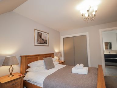 A bedroom with a bed and bedside table at Burnside House in Aviemore