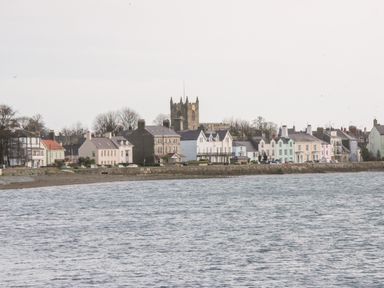 A coastline with houses and a church tower near the water at Seion Chapel in Beaumaris
