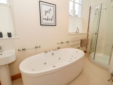 A bathroom with a bathtub shower enclosure sink and a towel rack at Seion Chapel in Beaumaris