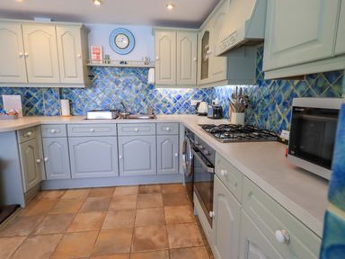 A kitchen with cabinets and appliances at Waterhead Cottage, Ecclerigg, near Troutbeck Bridge