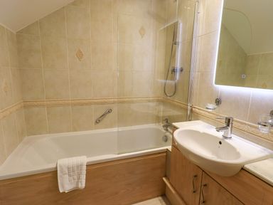 A bathroom with a bath tub and sink at Waterhead Cottage in Ecclerigg, near Troutbeck Bridge