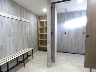 A changing room with a bench hooks and cubby shelves at Hazel Cottage in Poughill near Bude
