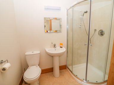 A bathroom with a toilet sink mirror and glass shower at Rossanean in Farranfore near Killarney County Kerry