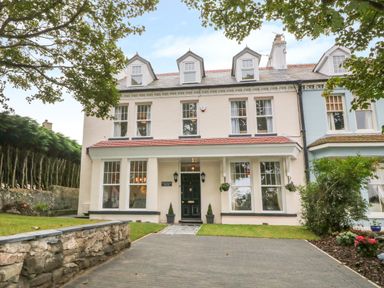 A large two story house with dormer windows and a driveway at Lyngaran House in Holyhead
