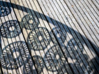 Shadows of a round patterned object on a wooden deck surface at Blue Bay Beach House in Mawgan Porth