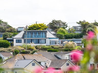 A view of multiple houses with gardens and greenery at Blue Bay Beach House in Mawgan Porth
