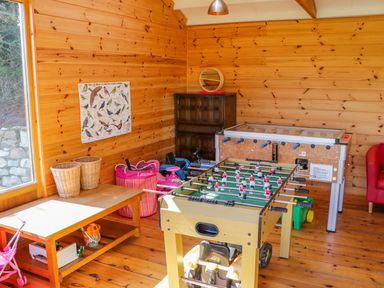 A wooden game room with foosball and other games at Lambkin Cottage in St Columb Major