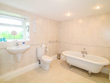 A bathroom with a pedestal sink toilet and clawfoot bathtub at Forget-me-not in St Columb Major