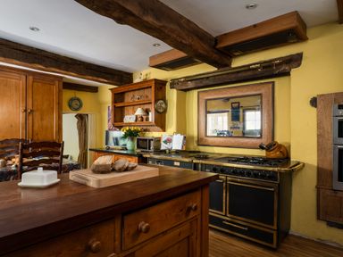 A kitchen with wood cabinets and a stove at The Meeting House in Ashburton