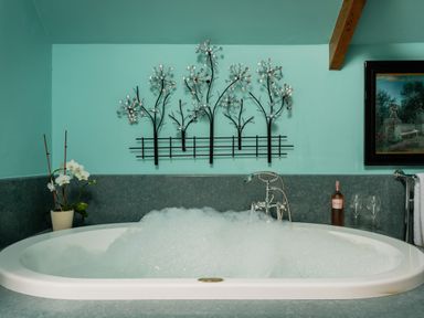 A bathtub with bubbles and decorative elements at The Meeting House in Ashburton