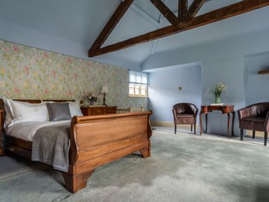 A bedroom with a bed and wooden furniture at The Meeting House in Ashburton