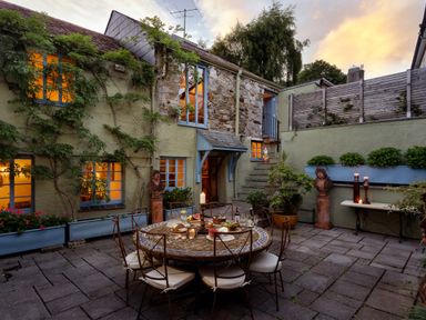 An outdoor dining area with a table and chairs at The Meeting House in Ashburton