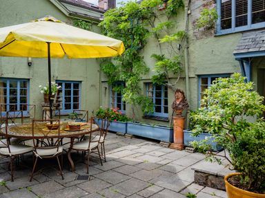A garden with a table and umbrella at The Meeting House in Ashburton