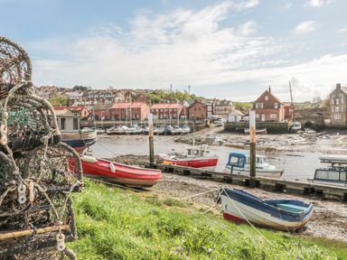 A harbor with fishing boats lobster traps and buildings by the water at Premier Transit & Lady Hilda @ Engine Shed in Whitby