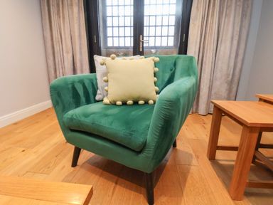 A chair with cushions in a living room at Premier, Transit &amp; Lady Hilda @ Engine Shed, Whitby