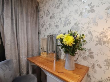 A dining room with a table, flowers in a vase, and a mirror at Premier, Transit & Lady Hilda @ Engine Shed, Whitby