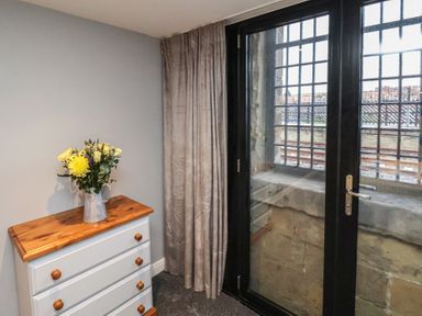 A bedroom with a dresser and flowers at Premier, Transit &amp; Lady Hilda @ Engine Shed, Whitby