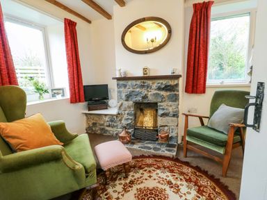 A living room with an armchair and a fireplace at Ael Y Bryn in Menai Bridge