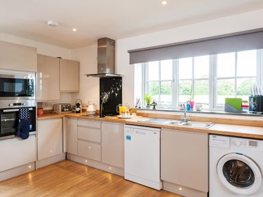 A kitchen with appliances wooden countertops and a window at Be Our Guest Cottage in Chacewater near Truro