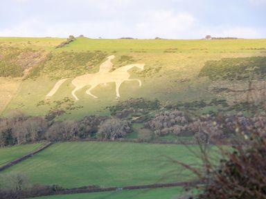 A hillside with a large chalk figure of a horse and rider in a grassy landscape at Duck Cottage in Sutton Poyntz